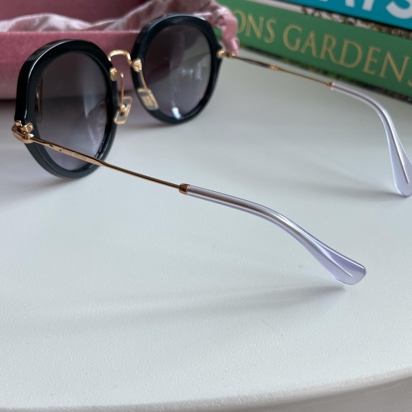 Miu Miu circular glasses in black and gold